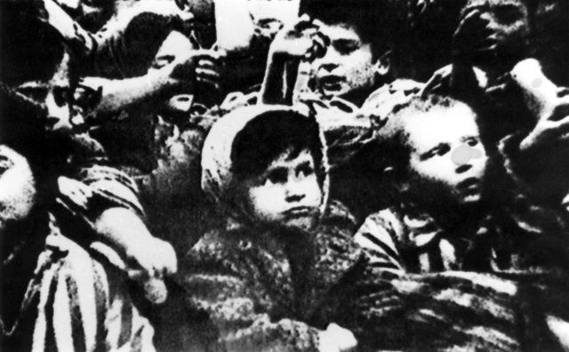 Kinder von Auschwitz zeigen nach der Befreiung des Vernichtungslagers durch die Rote Armee ihre Tätowierungen.