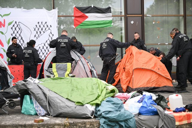 Polizeibeamte räumen nach der Räumung einer pro-palästinensischen Demonstration der Gruppe «Student Coalition Berlin» auf dem Theaterhof der Freien Universität Berlin das Camp ab.