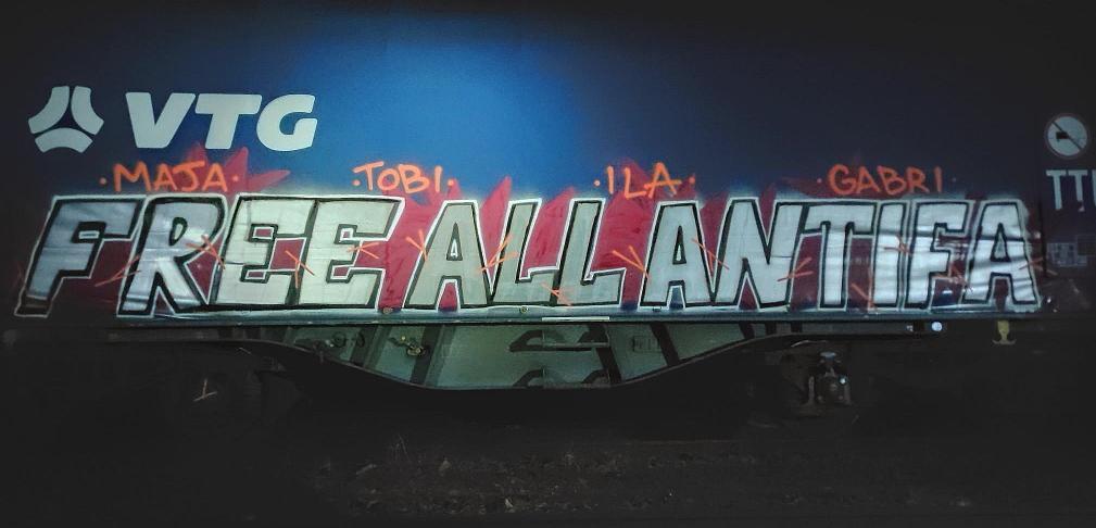 Graffiti in Solidarität mit Maja T. und anderen Beschuldigten im Budapester Antifa-Prozess auf einem Eisenbahnwaggon.