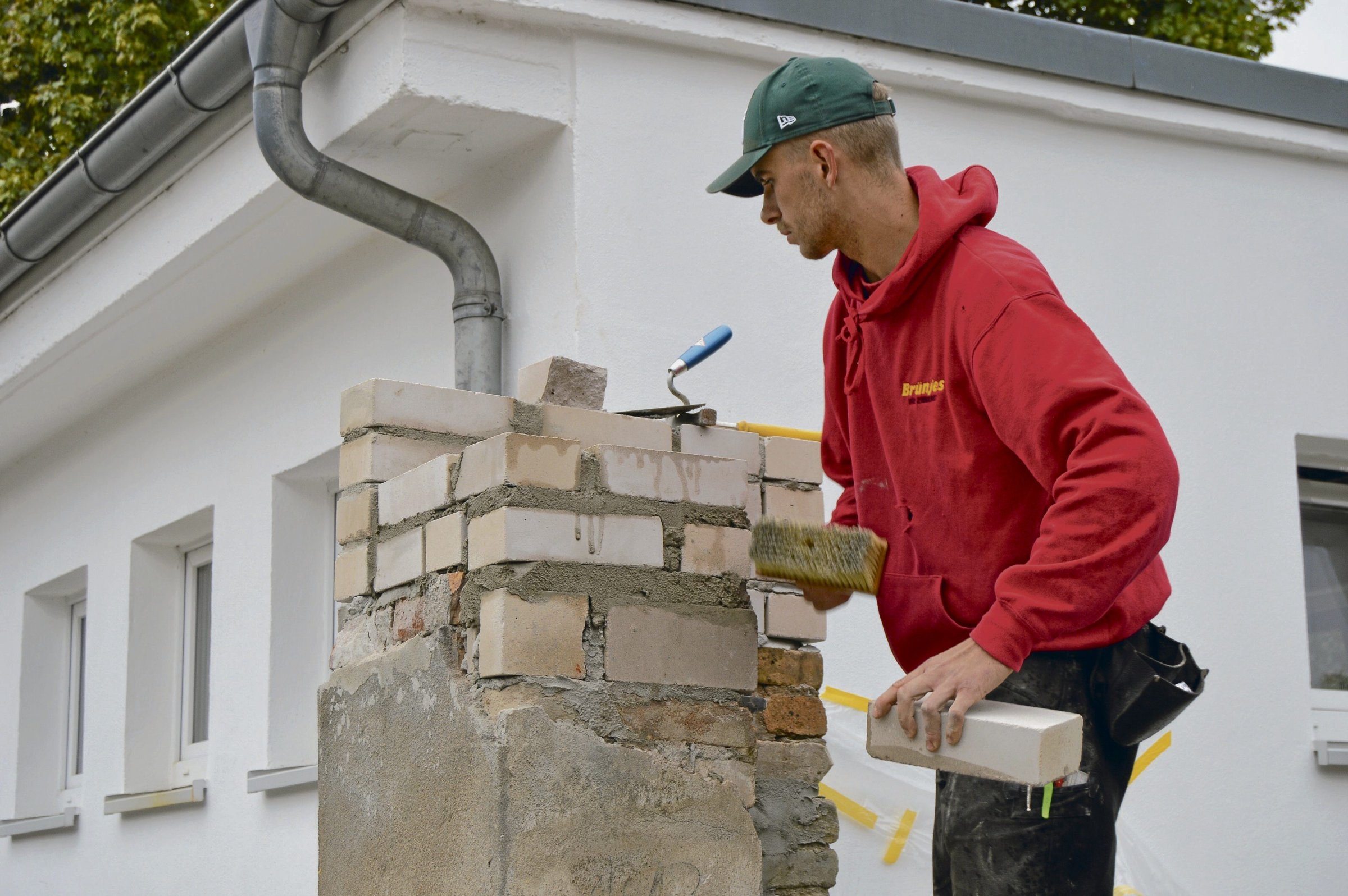 Marvin Bloedau bringt eine Toreinfahrt wieder in Schuss. 23 männliche und sieben weibliche Lehrlinge arbeiten eine Woche lang freiwillig in der Gedenkstätte Sachsenhausen.