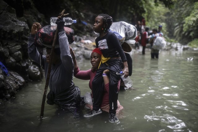 Menschen aus Haiti waten durch einen Grenzfluss von Kolumbien nach Panama. Die Biden-Administration will sie mit neuen Zentren schon in Mittelamerika abfangen.