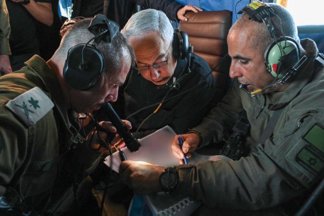 Als Kriegsherr fühlt sich der israelische Premierminister Benjamin Netanjahu (mitte) am wohlsten. Hier unternimmt er einen Rundflug über den Gazastreifen und wird vom Kommandeur der 162. Division über die Aktivitäten unterrichtet.
