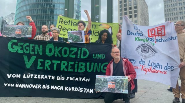 Deutsche und lateinamerikanische Umweltaktivisten protestieren vor dem Deutsche-Bahn-Tower in Berlin gegen umweltgefährdende Pläne.
