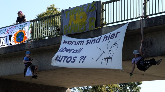 Aktivisten seilen sich von einer Brücke über der A27 ab und bringen Plakate an. Für die Demonstration sperrte die Polizei die Autobahn zwischen den Anschlussstellen Bremer Kreuz und Achim Nord vorübergehend voll.