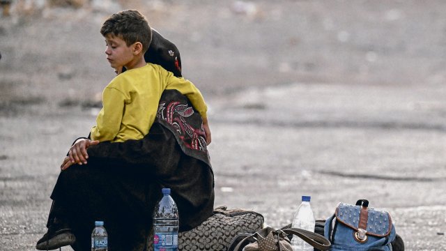 Auf der syrischen Seite der Grenze zum Libanon, in Dschdeidat Jabus im Südwesten Syriens, sitzt eine aus dem Libanon geflohene Frau mit einem Kind auf dem Schoß auf dem Boden.