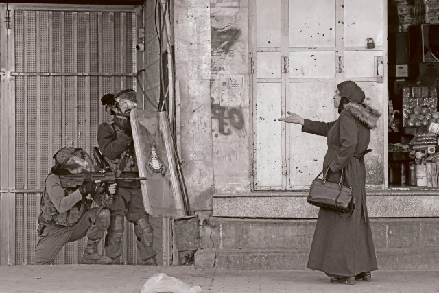 Eine Frau in Hebron im Westjordanland steht israelischen Soldaten gegenüber.