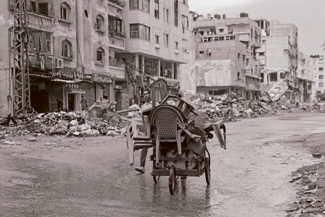 Ein Straßenverkäufer läuft durch die von Israel zerstörten Straßen in Gaza-Stadt.