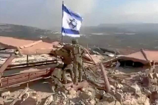 Ein Bild aus einem Video, das am 8. Oktober 2024 in den sozialen Medien veröffentlicht wurde, zeigt israelische Soldaten, die eine israelische Flagge im südlibanesischen Grenzdorf Marun Al-Ras hissen.