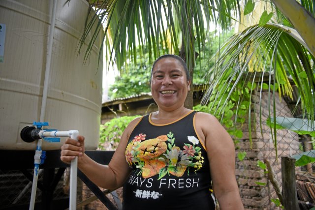 Sandra García neben ihrem neuen Tank, der bis zu 2500 Liter Regenwasser speichert.