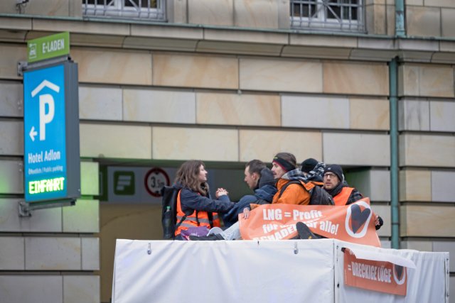 Aktivist*innen der Letzten Generation stehen mit einem Lkw vor einem Eingang ins Parkhaus des Adlon.