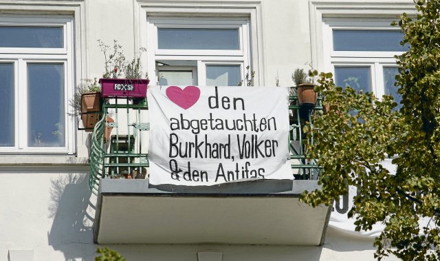 Von einem Balkon in der Hamburger Hafenstraße wünschen Bewohner*innen den abgetauchten Burkhard Garweg, Volker Staub und verfolgten Antifaschist*innen Freiheit und Glück.